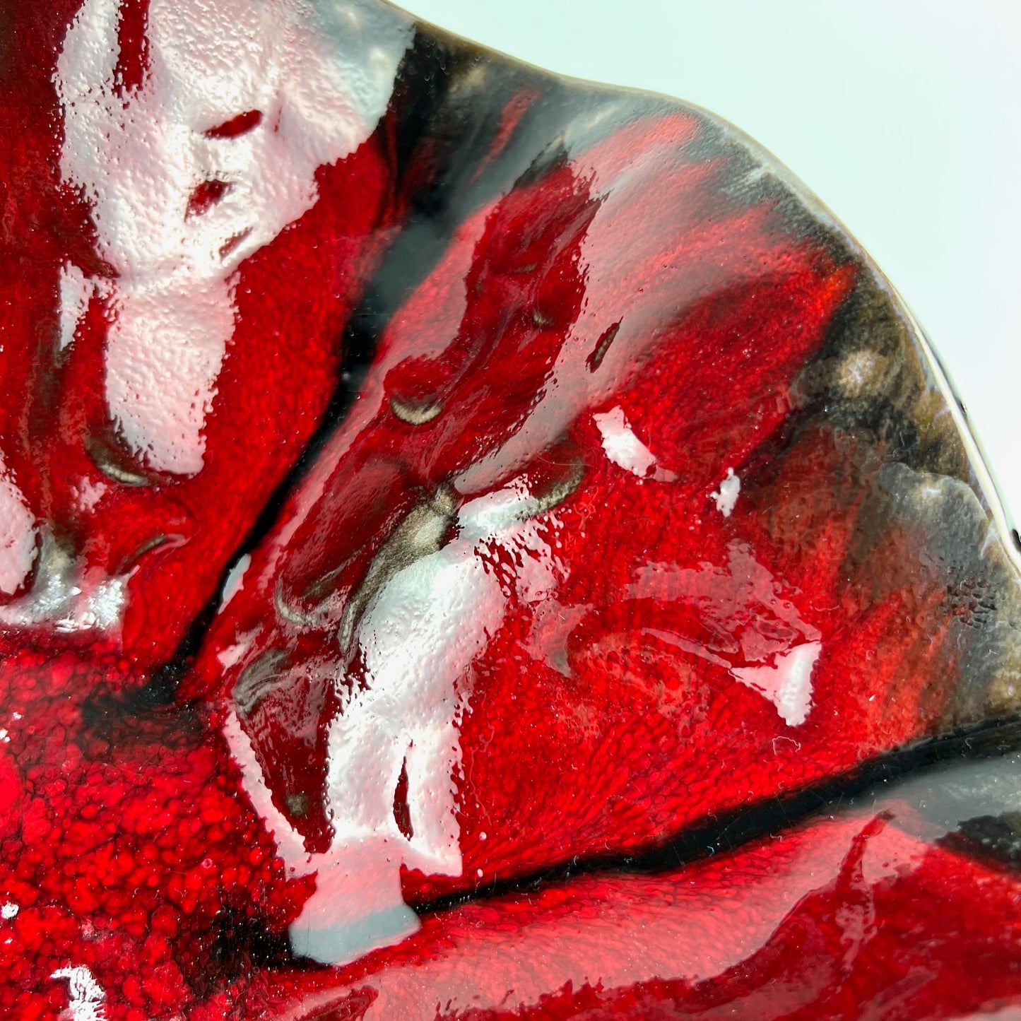 Close-up of the glossy rich red interior of a handmade large-sized ceramic bowl.