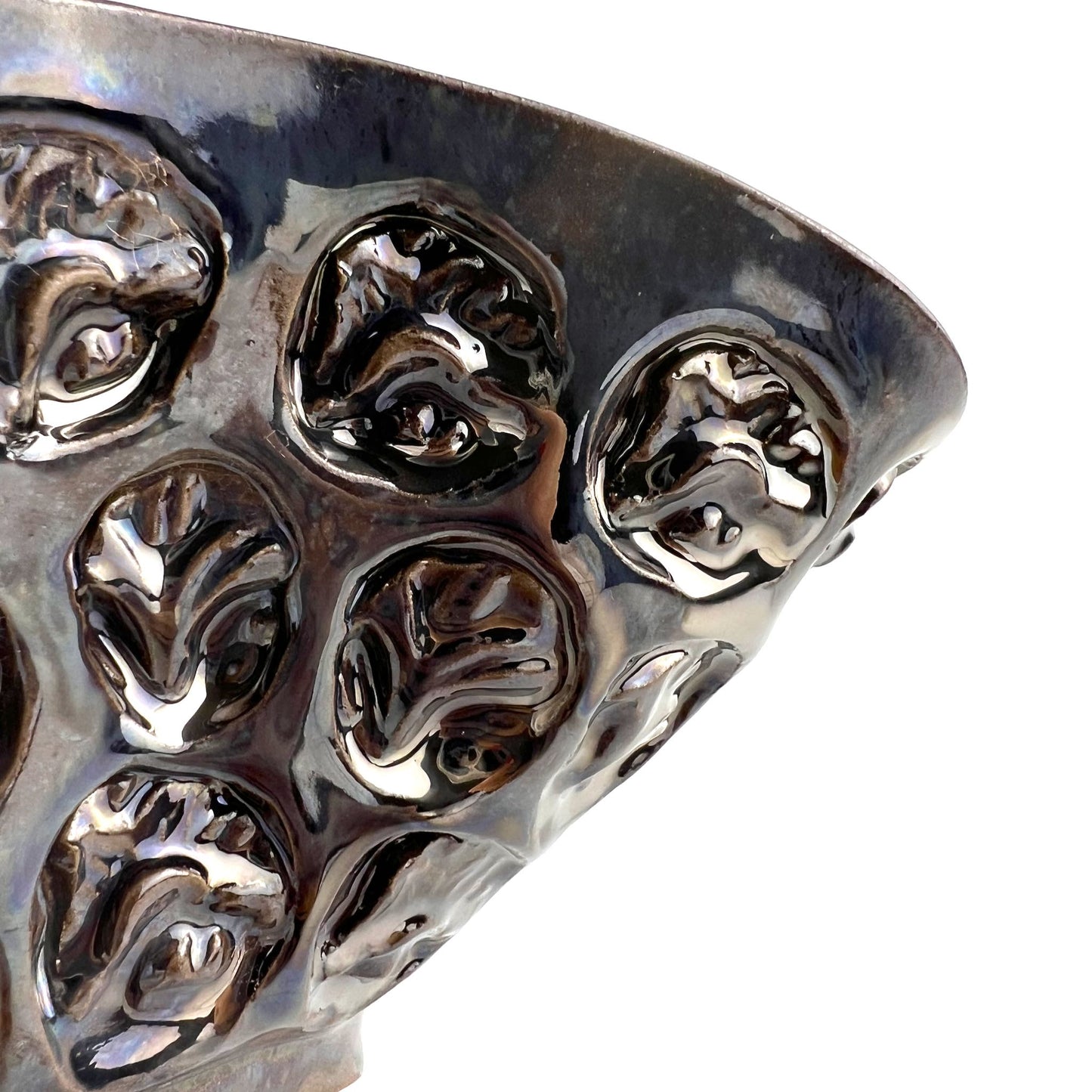 Close-up of the textured half-flower and tree exterior with dark metallic glaze on a medium-sized handmade ceramic bowl.