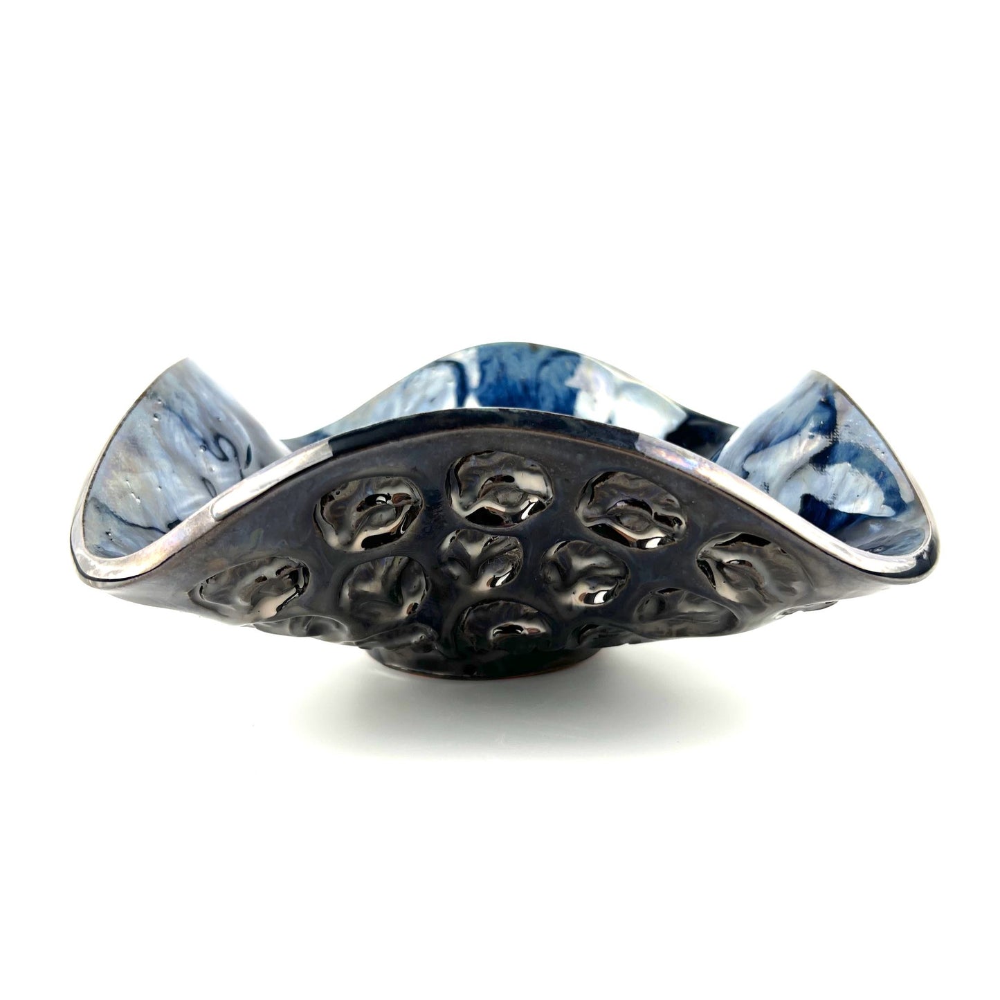 Side view of a handmade medium-sized decorative ceramic bowl featuring a glossy dark blue base with silver accents and half-flower and tree texture design.