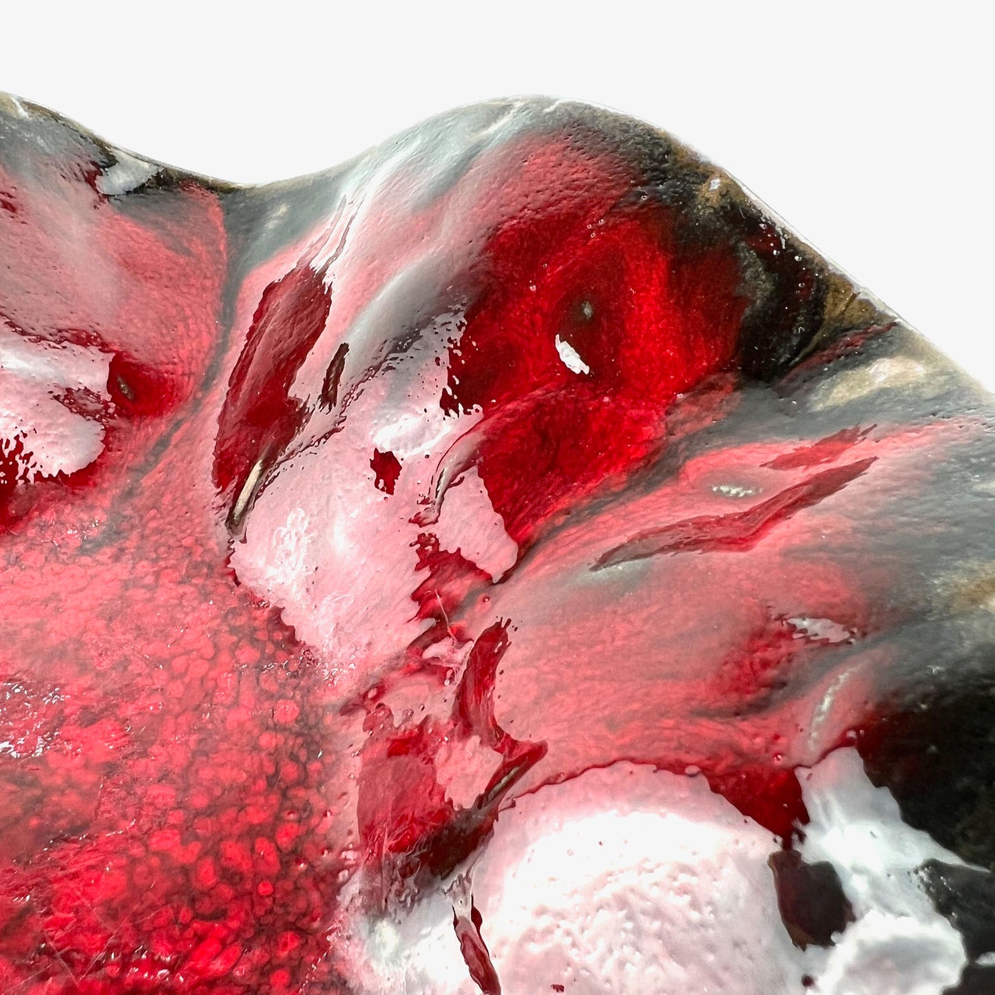 Close-up of the glossy rich red interior of a handmade medium-sized ceramic bowl.