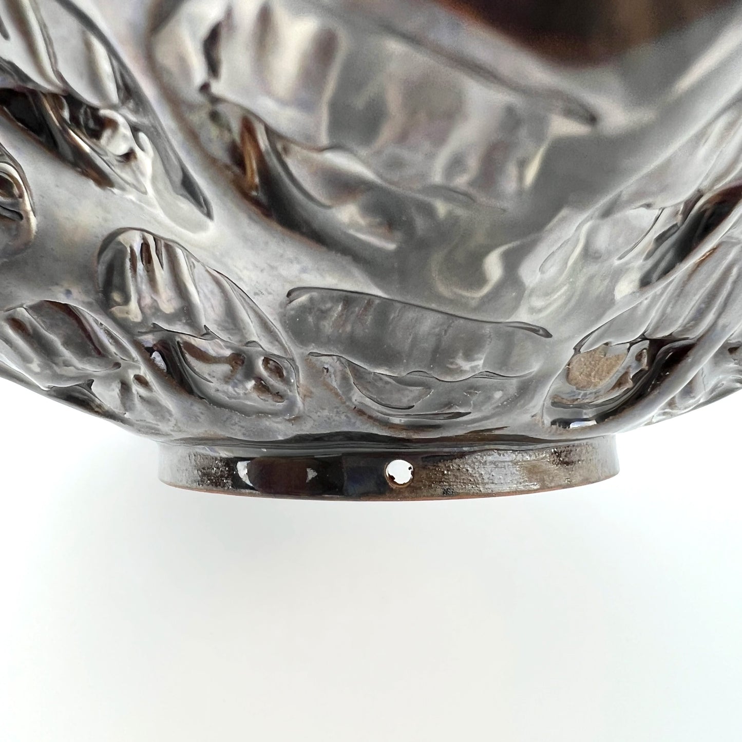 Close-up of the foot rim on a handmade small ceramic bowl, showcasing its ability to become wall art.