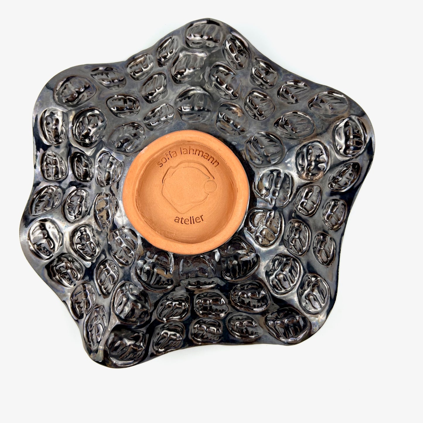 Top view of the textured hand exterior with dark metallic glaze on a handmade small ceramic bowl.