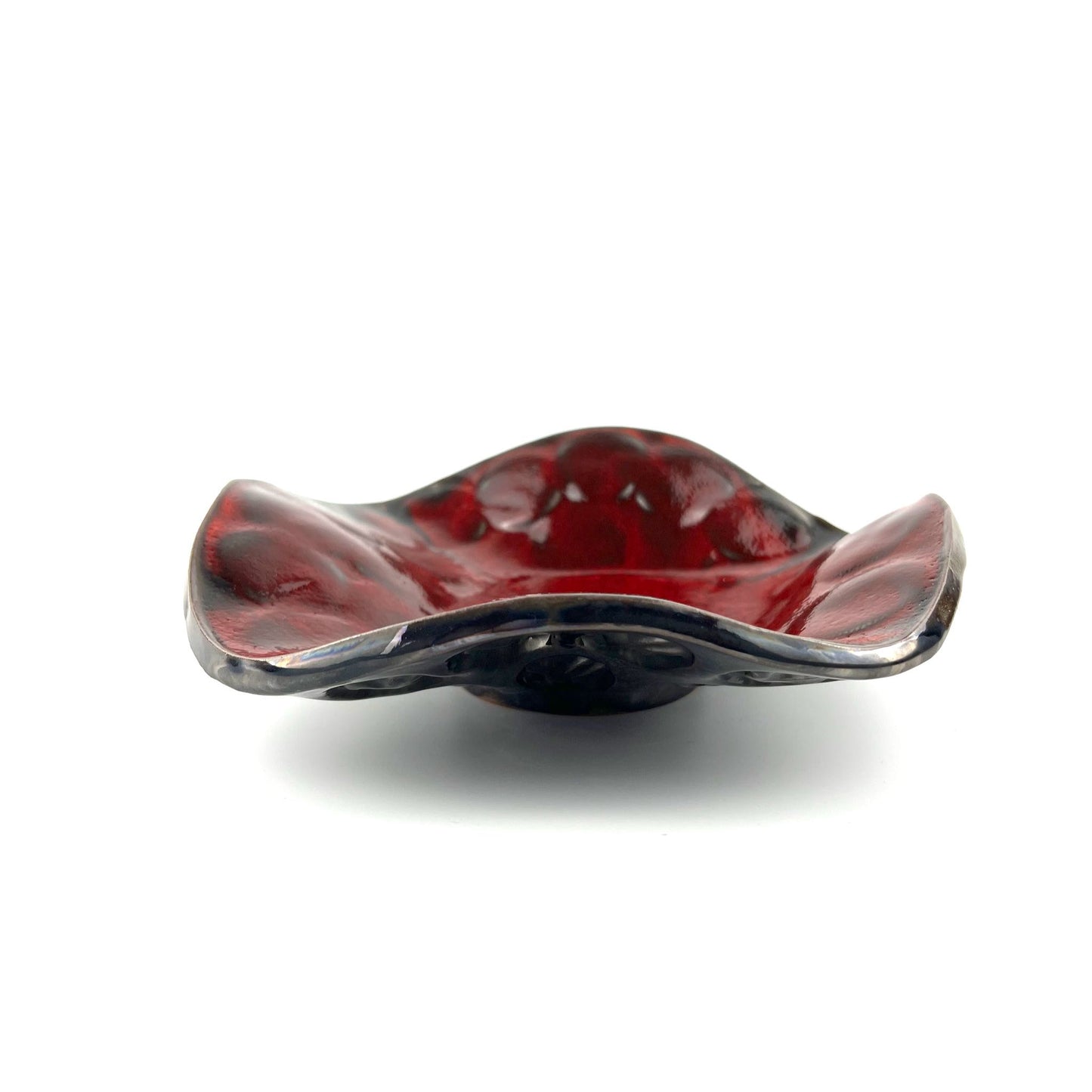 Side view of a handmade small-sized decorative ceramic bowl featuring a glossy rich red interior and tree texture design.