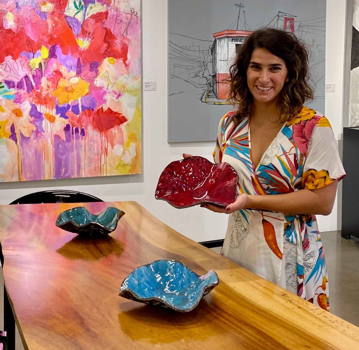 Woman in art gallery holding medium size red decorative ceramic bowl