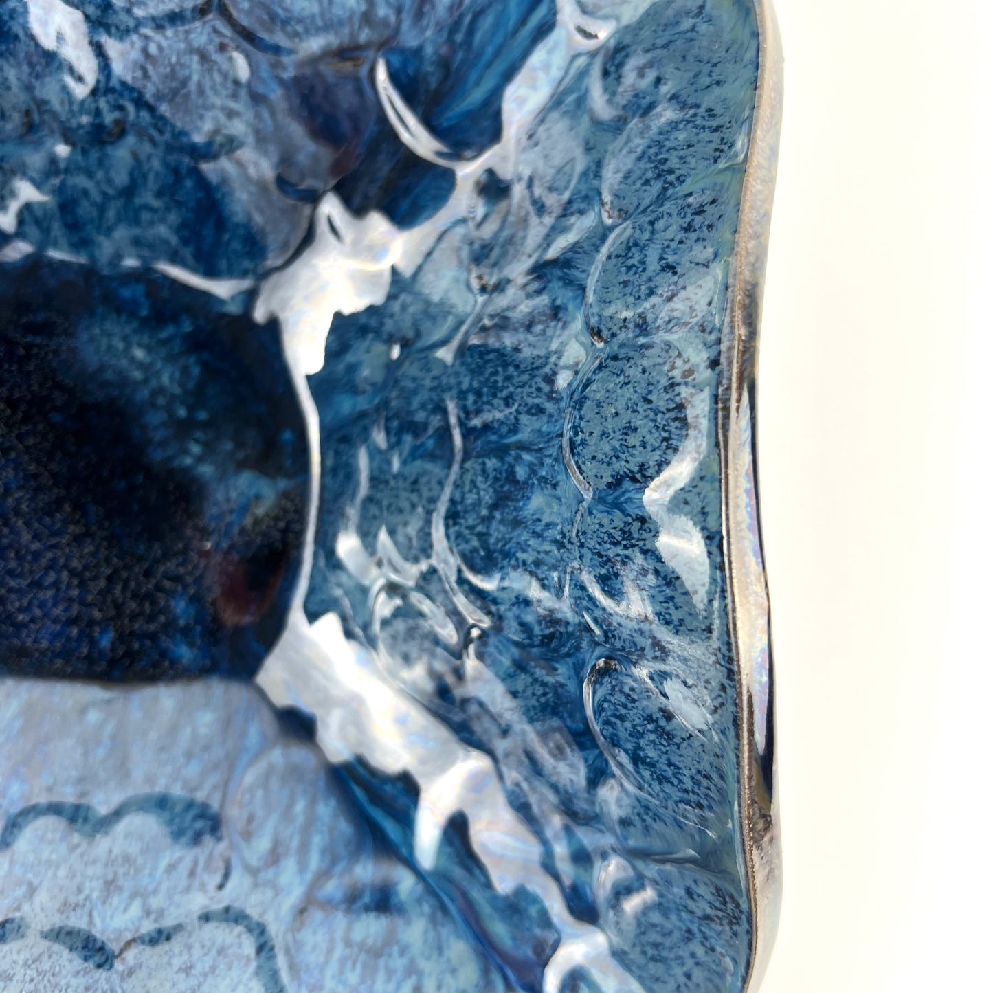 Close-up of the glossy royal blue interior of a handmade large-sized ceramic bowl.