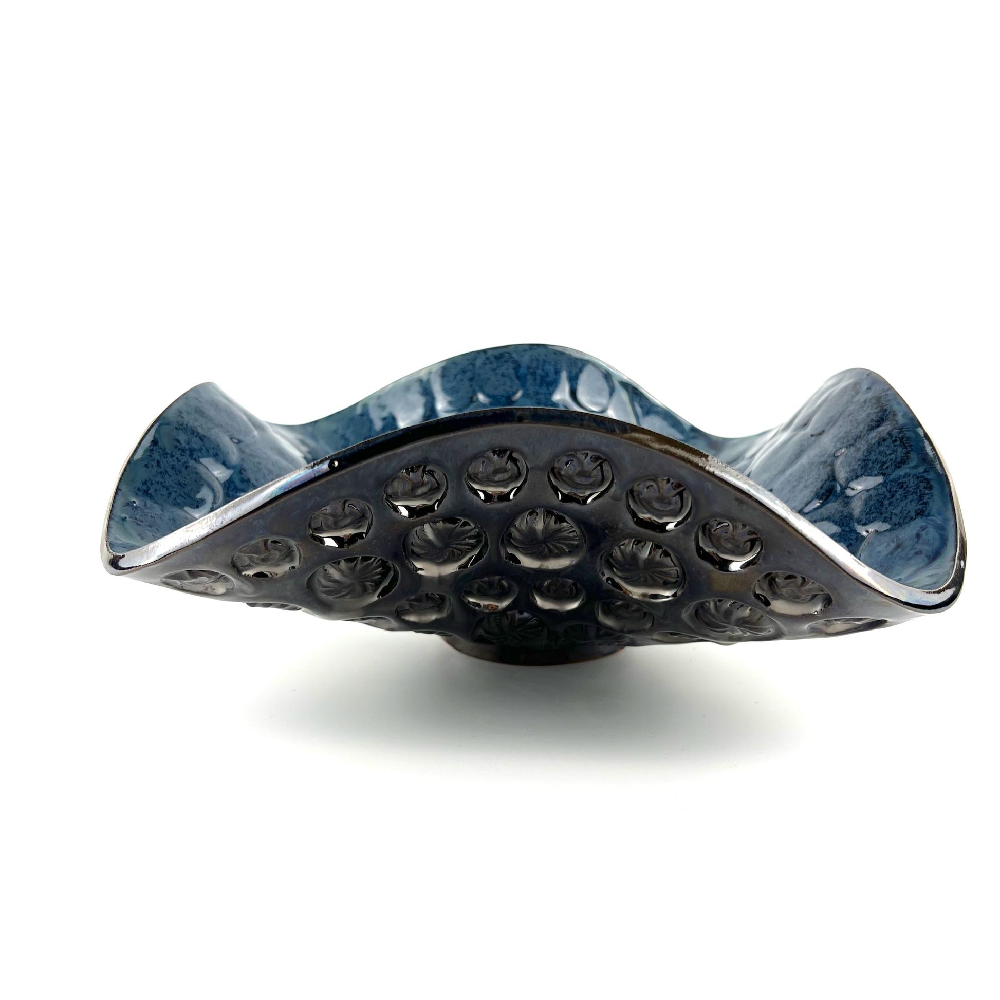 Side view of a handmade large-sized decorative ceramic bowl featuring a royal blue interior and sunshine and ant texture design.