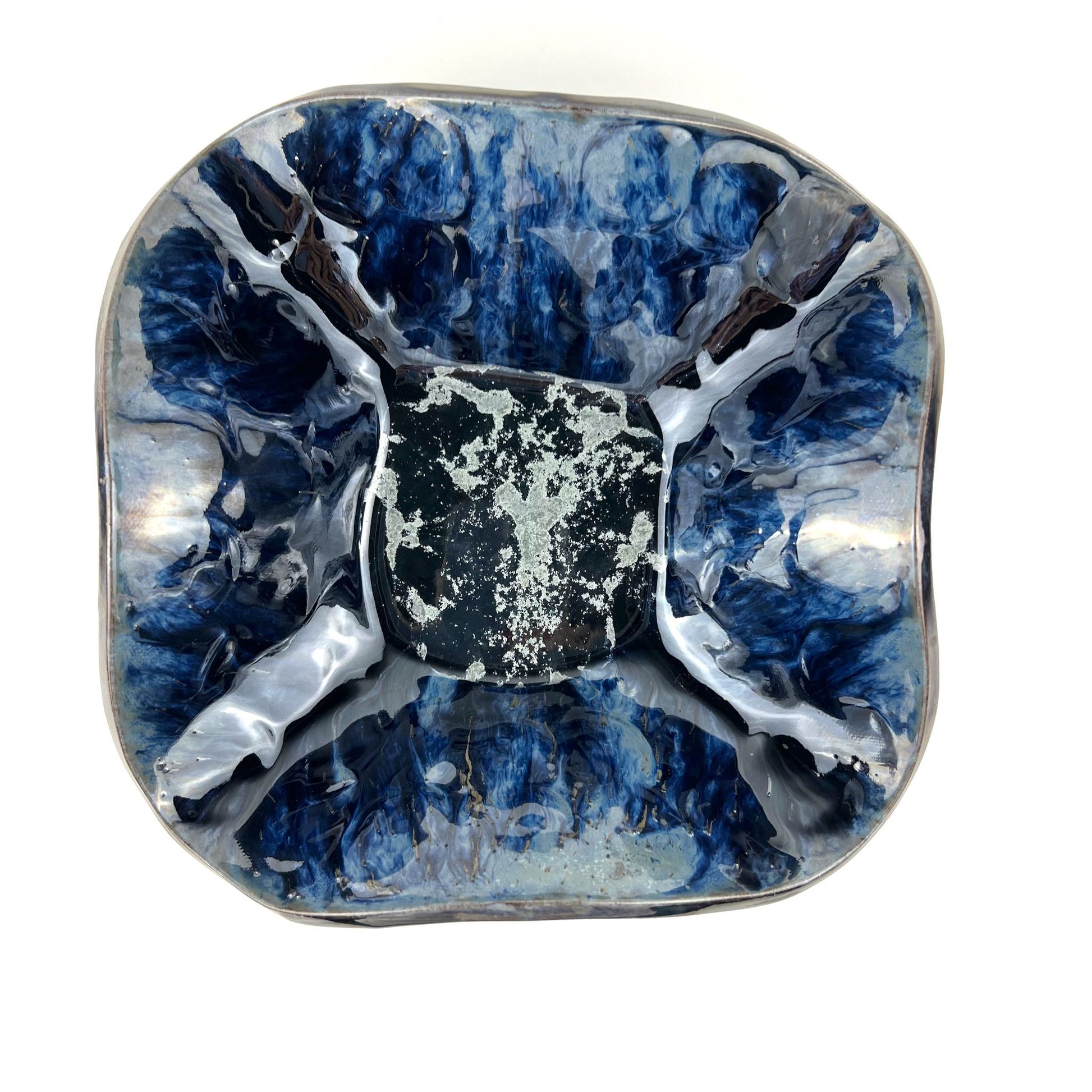 Top view of the glossy dark blue interior with silver accents of a handmade medium-sized ceramic bowl.