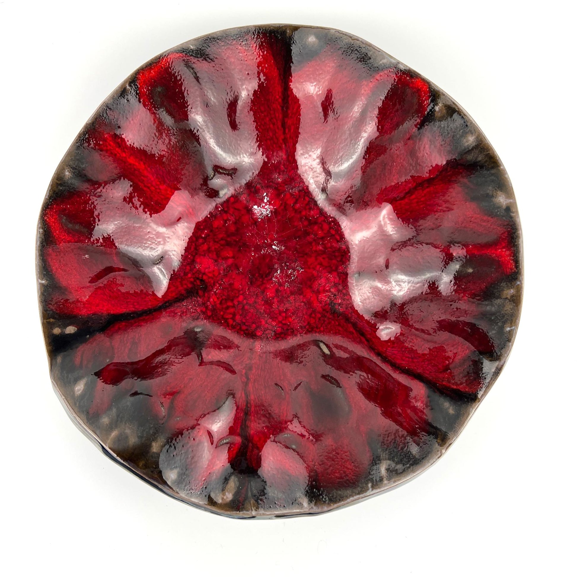 Top view of the glossy rich red interior of a handmade medium-sized ceramic bowl.