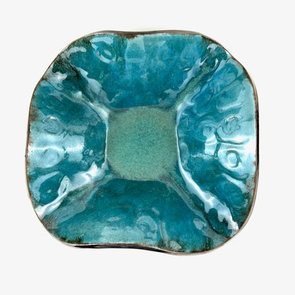 Top view of the glossy turquoise interior of a handmade medium-sized ceramic bowl.