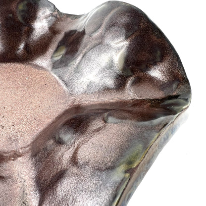 Close-up of the shimmering rose gold interior of a handmade small ceramic bowl.