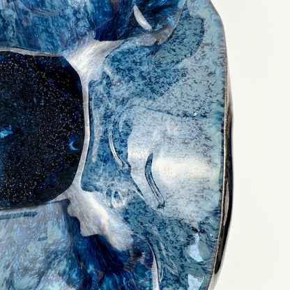 Close-up of the glossy royal blue interior of a handmade small ceramic bowl.