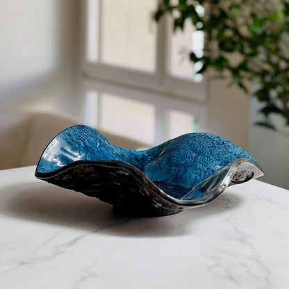 Handmade small decorative royal blue ceramic bowl with Trio of Leaves texture displayed on a marble table with a living room background.