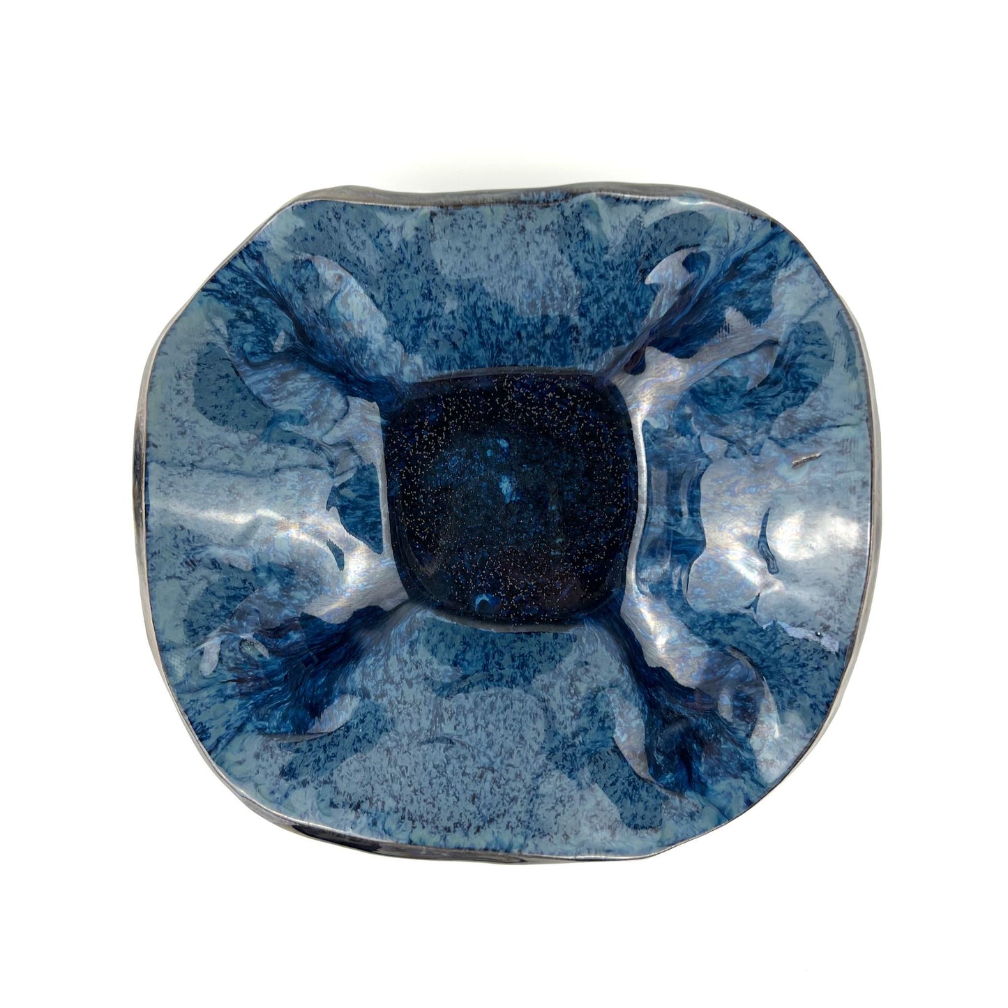 Top view of the glossy royal blue interior of a handmade small ceramic bowl.