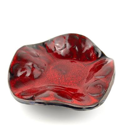 Handmade small-sized decorative ceramic bowl with a glossy rich red interior and textured tree design.