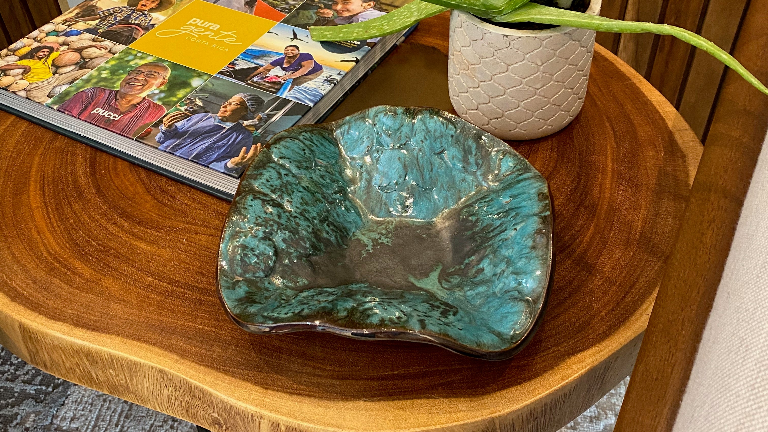 Green and silver decorative ceramic bowl in wooden coffee table