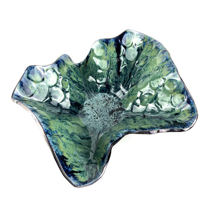 Handmade extra-large decorative ceramic bowl with a glossy cornflower blue base, navy, seafoam, and lime green accents, and textured sunshine design.